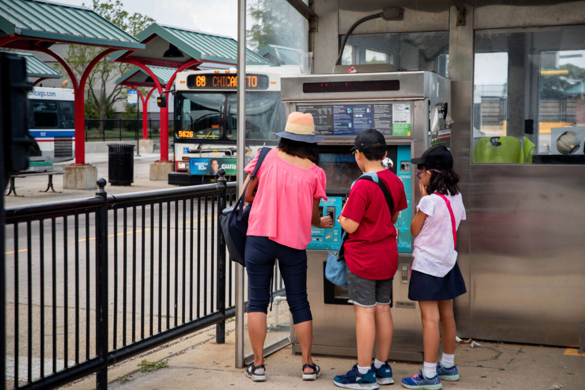 A mother with two children buying bus tickets at Ventra pay machine.