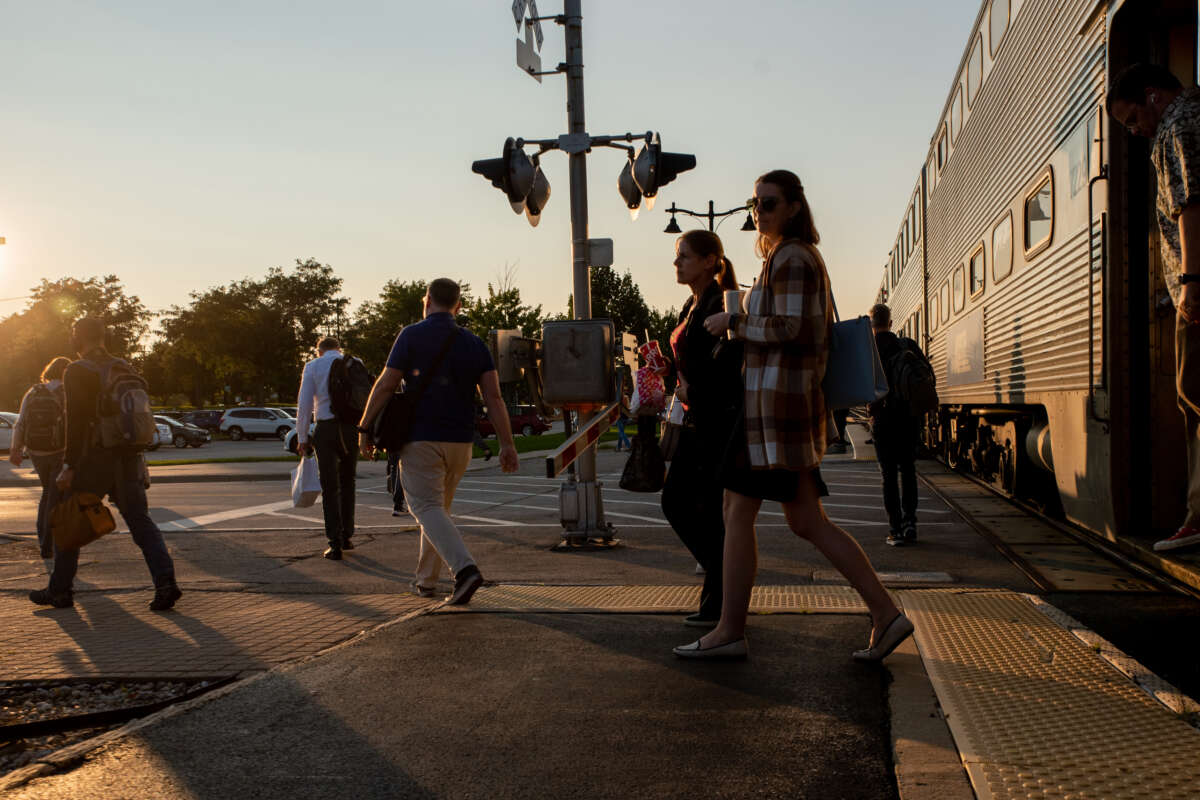 Commuters exiting Metra train at dusk.