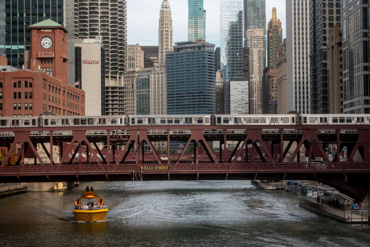 Scenic downtown Chicago train riding on tracks above the river.