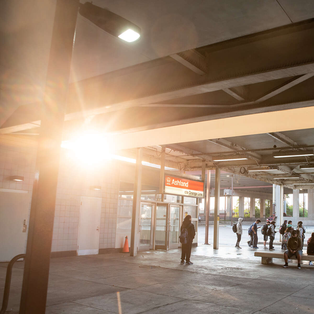Multiple people waiting outside for transit at Ashland Red Line train station.