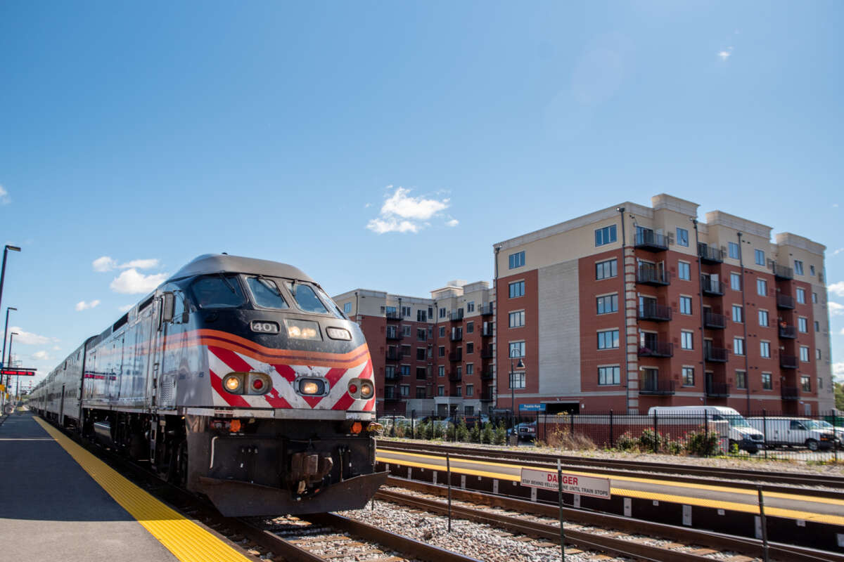 Metra train stopped in a suburb.