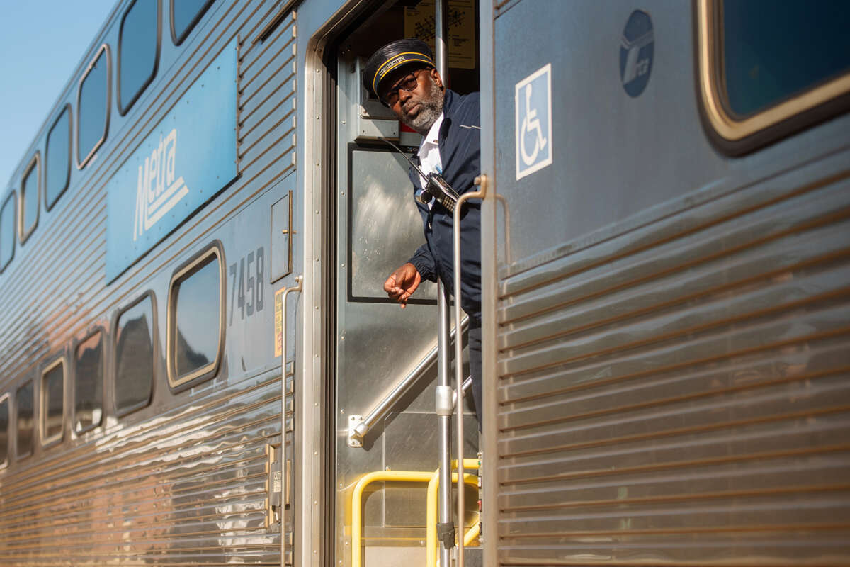 Train conductor looking out of Metra train stairway.